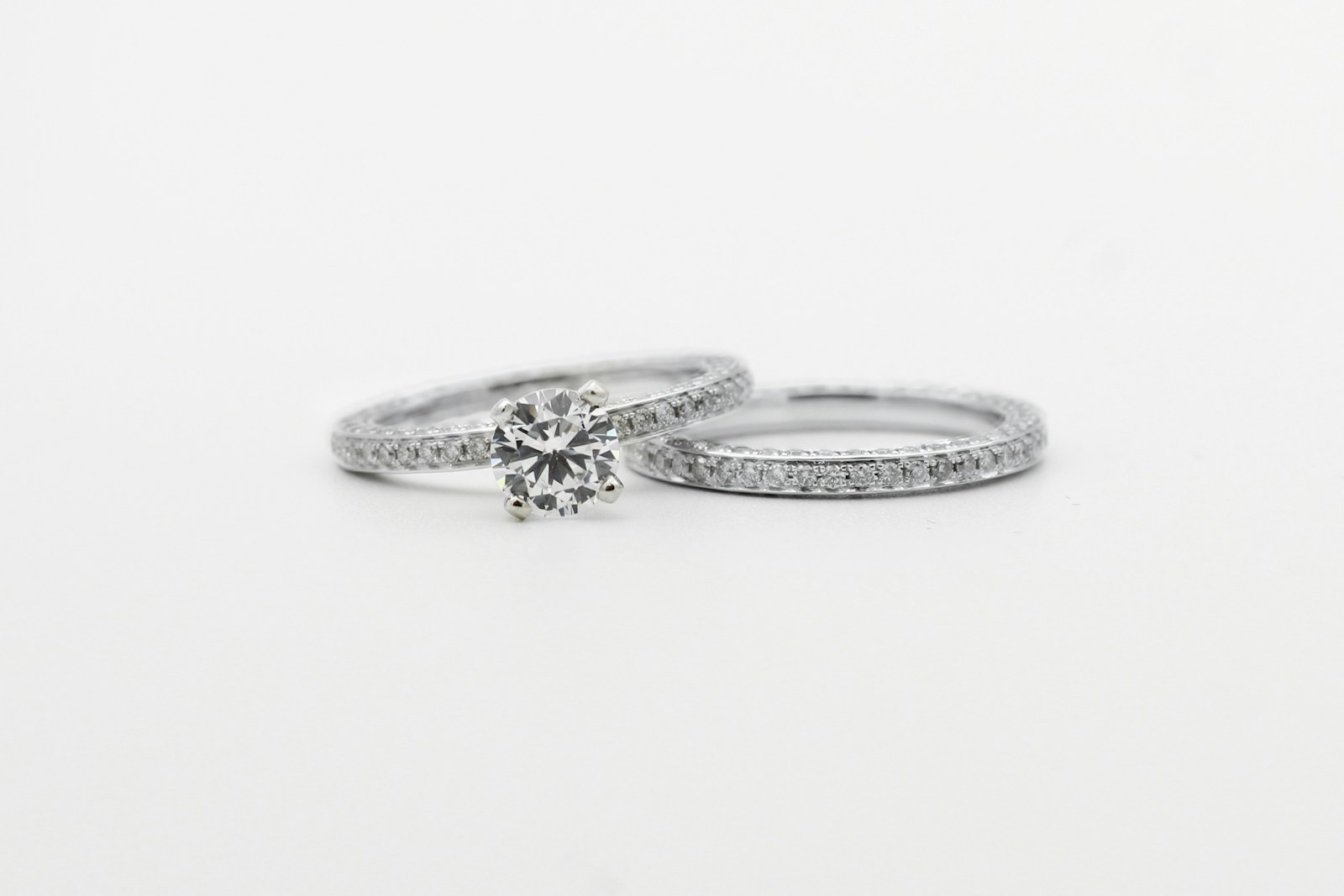 silver diamond studded ring on white surface